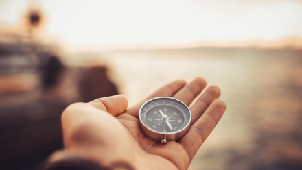 Hand holding a compass