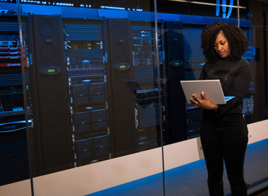 Woman on computer in data centre