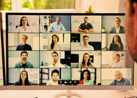 Two people watching a screen with an online meeting