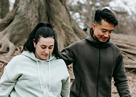 Young Asian trainer and woman walking in autumn