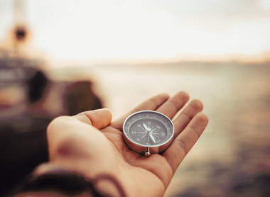 Hand holding a compass